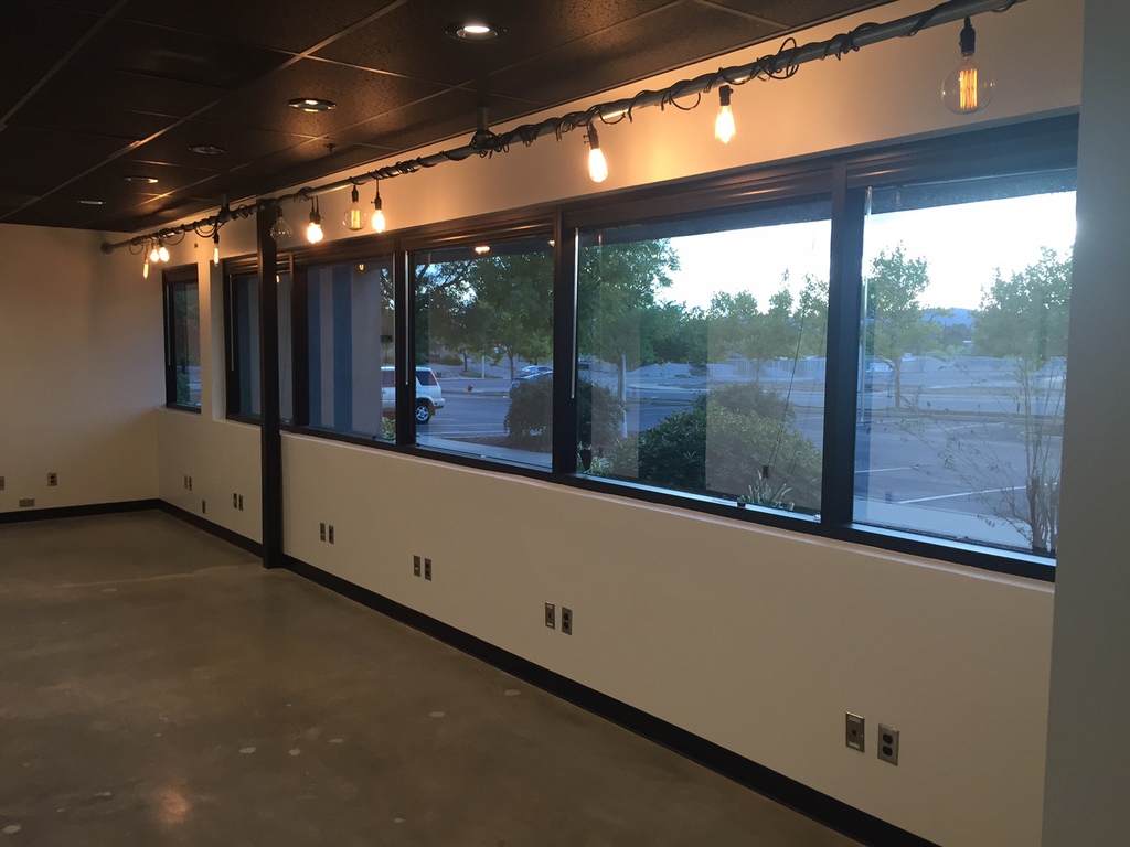 Commercial office interior in Redding with fresh white walls, dark ceiling grid and string lighting
